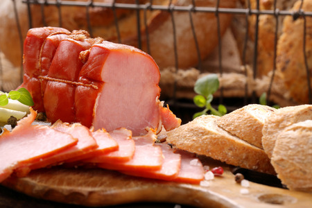 Fresh ham and bread on wooden background