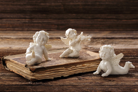 The old book and the three angels with empty space for textの写真素材