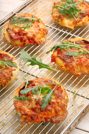 Small Pizza with mozzarella Cheese, ham and arugulaの写真素材