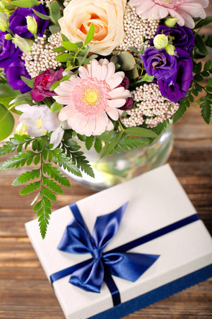 Blue gift box with beautiful bouquet of flowers with space for inscriptionの写真素材