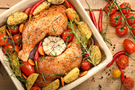 Chicken legs with vegetables and herbs ready for roasting


の写真素材