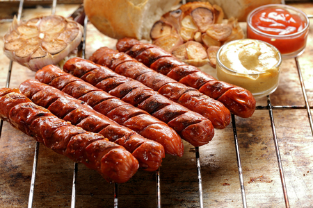 Grilled sausages in oven pan with garlic and onionの写真素材