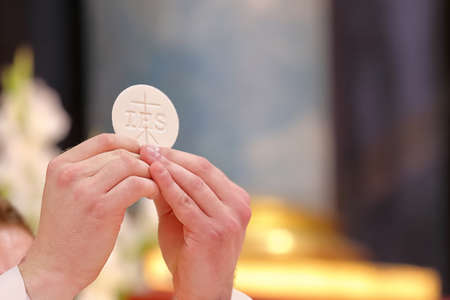 Holy host in the hands of the priest on the altar during the celebration of the mass and empty space for textの素材 [FY310157994009]