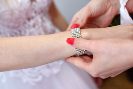Diamond bracelet put on the bride's hand by mom and empty space for textの写真素材