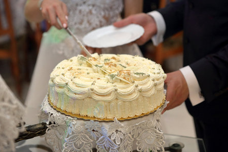 Bride and Groom cutting the wedding cake on the wedding partyの写真素材