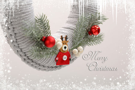 Christmas wreath made of yarn with Merry Christmas inscription. Decorated wreath with spruce twigs, reindeer and Christmas baublesの写真素材