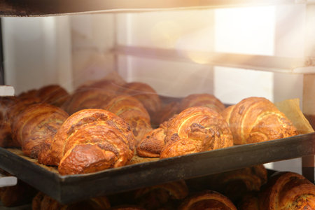 Fresh croissants taken out of the oven in a pastry shop and empty space for text
