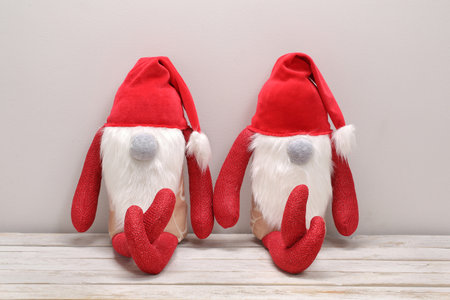 Two Christmas Elves are sitting on a bench, textile toys and empty space for the inscriptionの写真素材