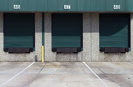 Three green warehouse loading bays at industrial complexの写真素材