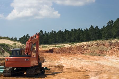 Strata of rock and dirt with heavy equipment on road construction project