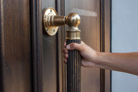 Hand opening the door knob, close-up of the handle.の写真素材