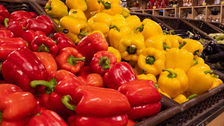 Red, yellow and green bell peppers on the counter of a grocery store