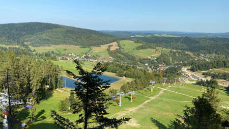 A view from the SÅotwiny Arena ski slope to the Beskid SÄdecki mountains, lots of forests and greeneryの写真素材