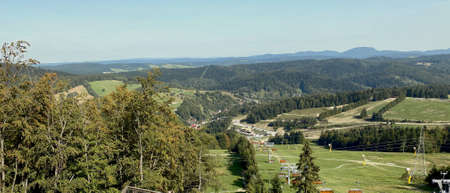 A view from the SÅotwiny Arena ski slope to the Beskid SÄdecki mountains, lots of forests and greeneryの写真素材