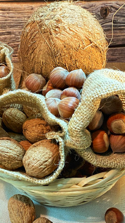 walnuts and hazelnuts in burlap bags coconuts in a wicker basketの写真素材