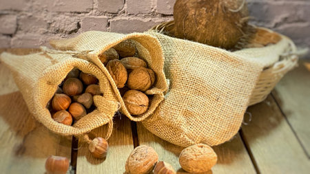 walnuts and hazelnuts in burlap bags coconuts in a wicker basketの写真素材
