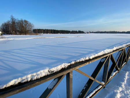 View of the frozen BiaÅe Lake near WÅodawa with wooden decks a lot of snow just before sunset golden hourの写真素材