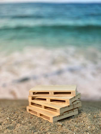 by the sea, wooden pallets lie on the sand at the beach