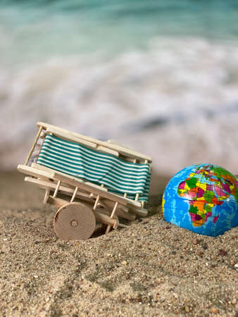 at the seaside wooden cart and a globe on the beachの写真素材