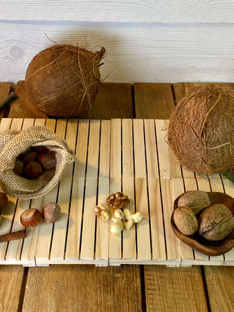 coconut walnuts and hazelnuts lie on wooden pallets that lie on the oak table in the background hay of pine boards painted whitet lie on the oak table in the background hay of pine boards painted whiteの写真素材