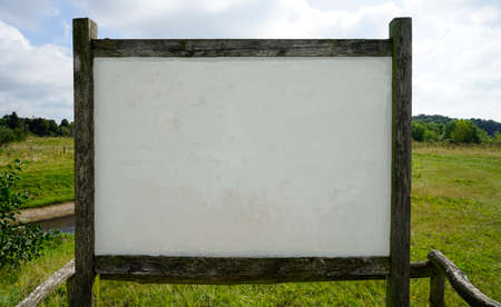 A blank information board in a park with copy space for  text or advertising. The gray-white space is weathered.の写真素材