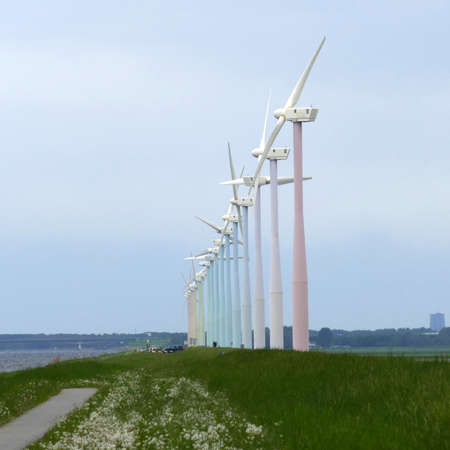 Unconventional wind turbines. They are pastel colored and have two blades instead of three.の写真素材