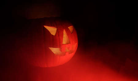 Evil Jack-o-lantern in red steam. Halloween nightmare with carved pumpkin in the darkness.の写真素材