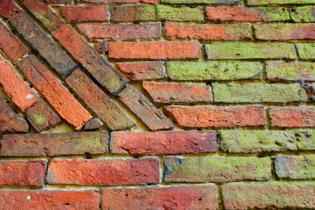 An old brick wall partly with moss and algae overgrown. Meant as background