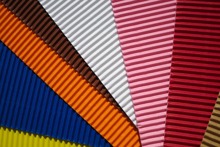 Set of diagonally ribbed cardboard pieces in the colors yellow, dark blue, orange, brown, white, pink, red and beige. Meant as backgroundの写真素材