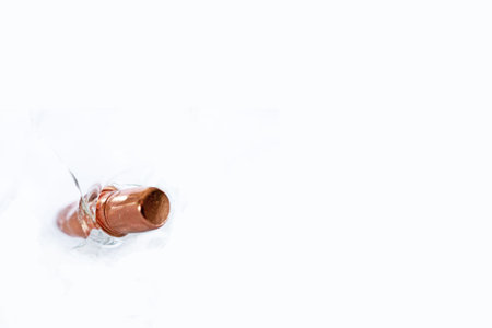 A copper colored bullet stuck in glass on a white background. With space for textの写真素材