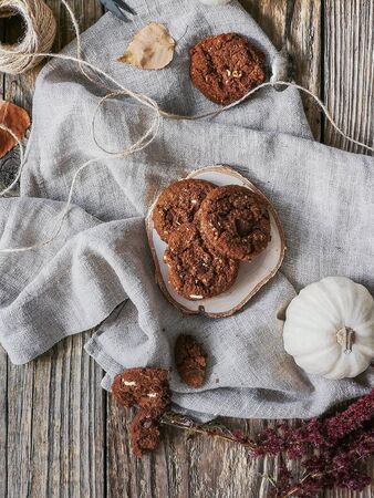 Flat lay of Chocolate cookies on wooden plate on white clothの写真素材