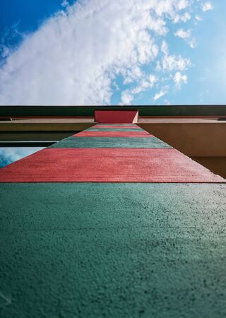 Upward look to colorful red and green pillar and blue cloudy skyの写真素材