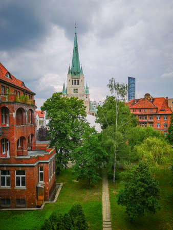 Wroclaw Poland 1 June 2019 Cathedral tower with green roof and Sky tower at cloudy day seen from old abandoned hospitalのeditorial素材