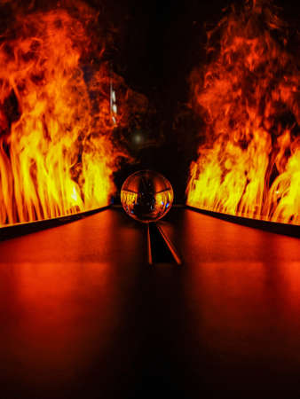 Glassy crystal lensball between paths with fake fireの写真素材