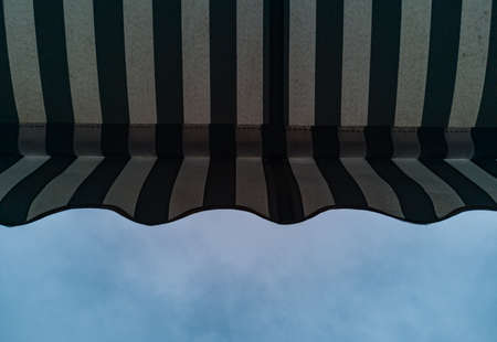 Upward view to shop awning with black and white stripesの写真素材