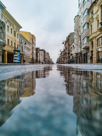Lodz, Poland - February 21 2020 Long Piotrkowska street reflected in small puddleのeditorial素材