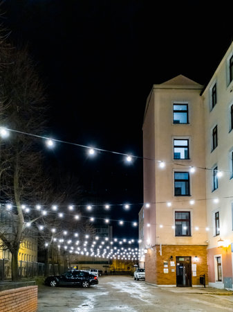 Lodz, Poland - February 21 2020 Small square near old tenement house with hanging glowing lightsのeditorial素材