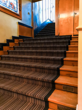 Lodz, Poland - February 22 2020 Old wooden stairs with carpet in old schoolのeditorial素材
