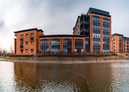 Lodz, Poland - February 22 2020 Facade of high red brick apartment building near small pondのeditorial素材