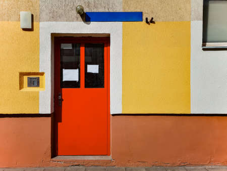 Red steel doors of block of flats with colorful wallsの写真素材