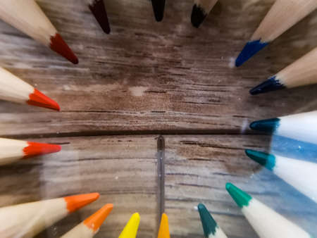 Colorful pencil crayons lie in a circle on wooden floorの写真素材