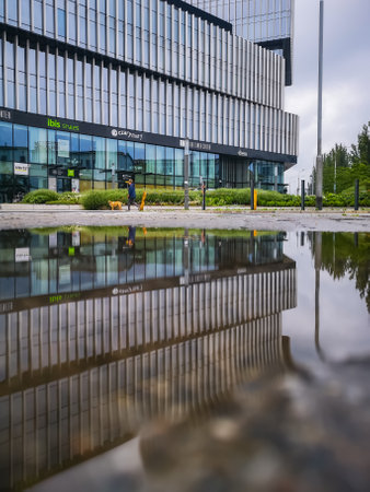 Wroclaw, Poland - June 19 2020: Facade of Silver Tower Center building reflected in puddle
