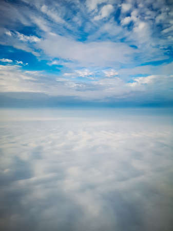 Aerial view from plane to morning sunrise over clouds