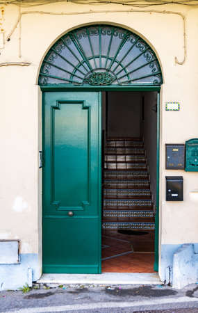 Large green doors with arc window over it as entrance to old tenement houseの写真素材