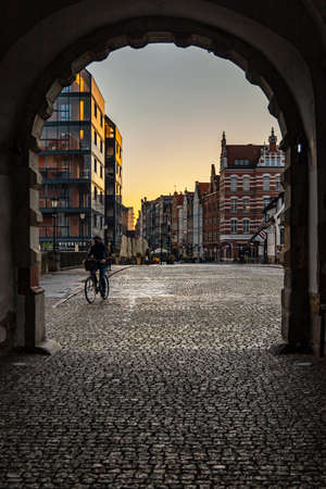 Gdansk, Poland - October 24 2020: Big city gate called Green Gate at morning with cyclist behind