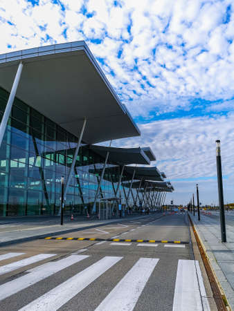 Wroclaw, Poland - November 4 2020: Street and facade of airport building with glassy wall at sunny cloudy dayのeditorial素材