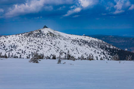 Snowy landscape of mountain trails and hills at cloudy morning