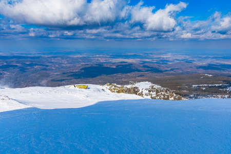 Snowy landscape of mountain trails and hills at cloudy morningの写真素材