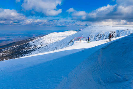 Snowy landscape of mountain trails and hills at cloudy morningの写真素材