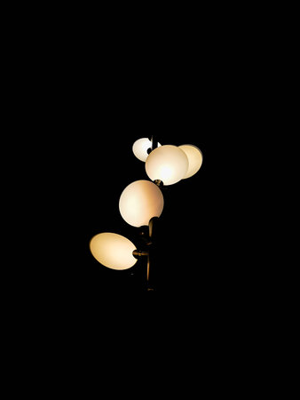 Looking up to round outdoor lamps glowing at night